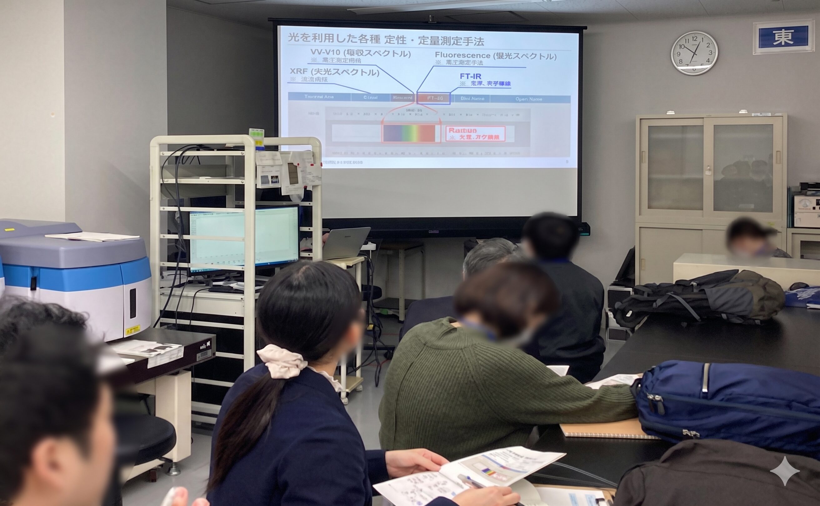 スライド資料を見ながら、講義や説明を受ける人々の様子